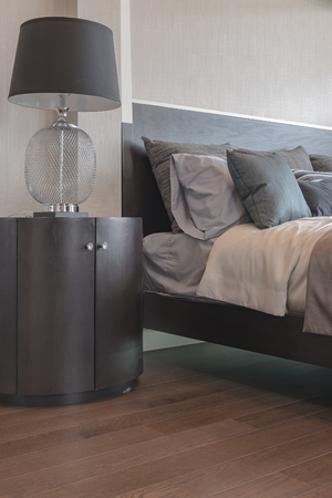 pillows on bed and luxury black lamp style on wooden table side in bedroom designの写真素材