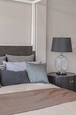 pillows on bed and luxury black lamp style on wooden table side in bedroom designの写真素材