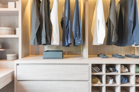 clothes hanging in wooden walk in closet, modern styleの写真素材