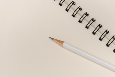white pencil with blank notebook on white backgroundの写真素材