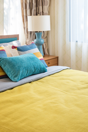 colorful pillows on wooden bed in modern bedroom design with wooden tray of tea setの写真素材