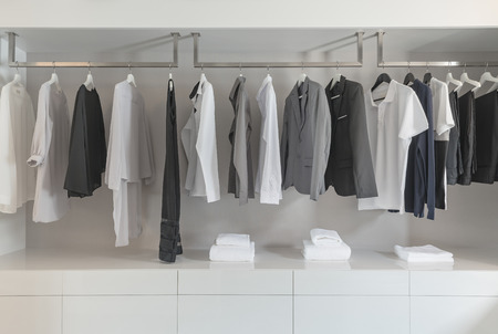 black and white color tone clothes hanging on rail in white closetの写真素材