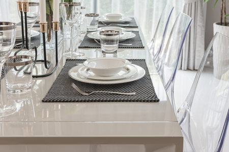 table set in luxury dining room with translucent chairの写真素材