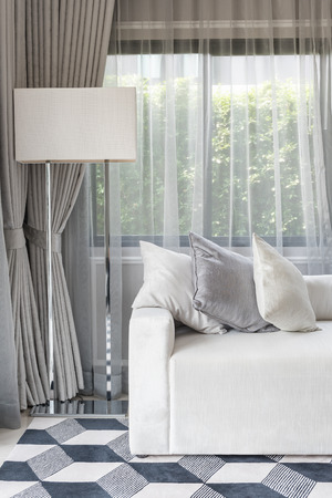luxury white sofa with pillows set in living room with white lamp on floorの写真素材