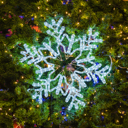 snowflake light on christmas treeの写真素材
