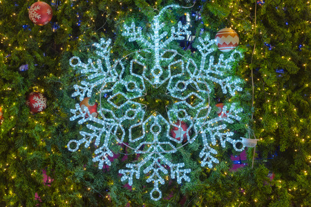 snowflake light and decorative ornament with red and white ball on christmas treeの写真素材