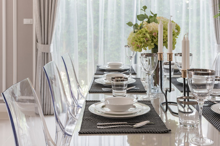 table set in luxury dining room with translucent chairの写真素材