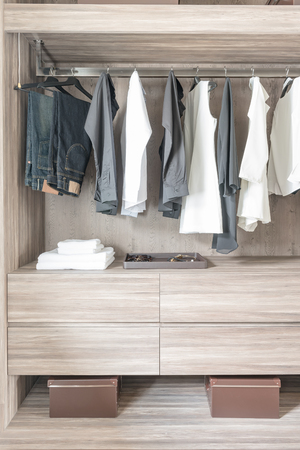 black and white color tone clothes hanging in wooden closetの写真素材
