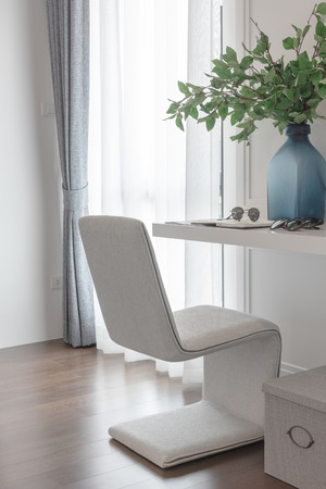 modern white chair in working space with vase of flower on white tableの写真素材