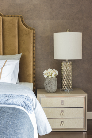 luxury bedroom with set of pillows on bed and white lamp on table sideの写真素材