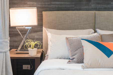 modern lamp and vase of plants on table side in modern bedroom designの写真素材
