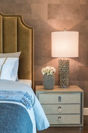 luxury bedroom with set of pillows on bed and white lamp on table sideの写真素材