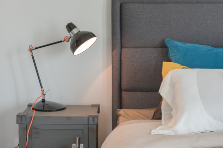 modern black lamp on table side in modern bedroom with set of pillowsの写真素材