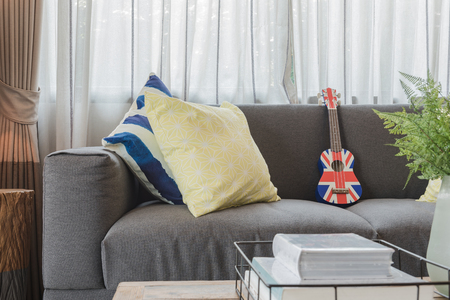 set of pillows on modern grey sofa in living room with lamp on wooden table sideの写真素材