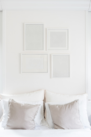white blank picture frames hanging on white wallの写真素材