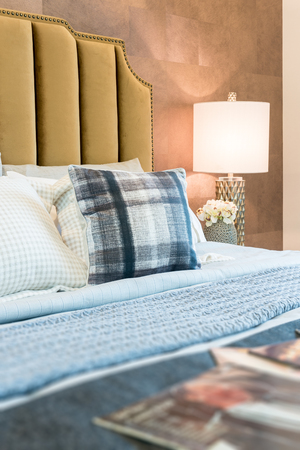 luxury bedroom with set of pillows on bed and white lamp on table sideの写真素材