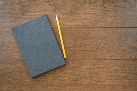 notebook with pencil on office wooden table with copy spaceの写真素材