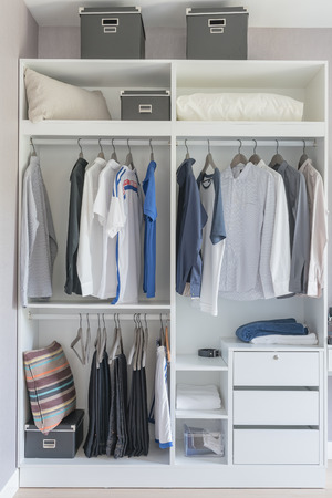 clothes hanging on rail in modern white wardrobe designの写真素材
