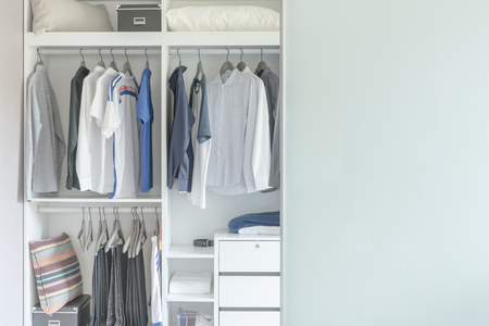 clothes hanging on rail in modern white wardrobe designの写真素材