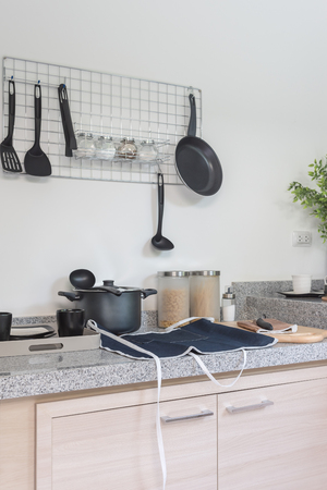 iron frying pan and utensils hanging on the wall in kitchen roomの写真素材