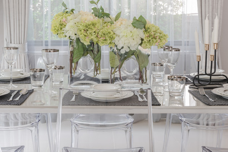 luxury dining room with translucent chair and vase of flowerの写真素材