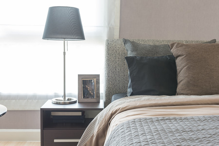 black modern lamp on wooden table side in modern bedroom designの写真素材
