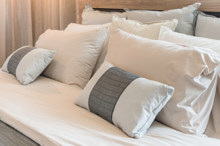 set of pillows on modern bed in bedroom interior designの写真素材