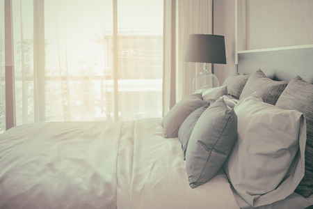pillows on bed and luxury black lamp style on wooden table side in bedroom design, vintage process styleの写真素材