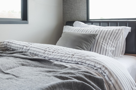 set of pillows with blanket on modern wooden bed in modern bedroom interior designの写真素材