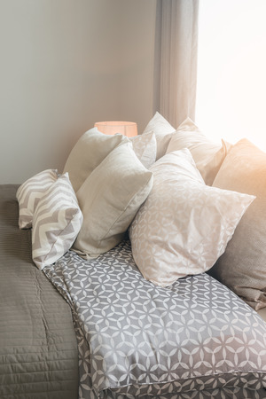 set of pillows on bed in cozy bedroom interior designの写真素材
