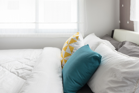 colorful pillows on white bed in modern bedroom, interior design conceptの写真素材