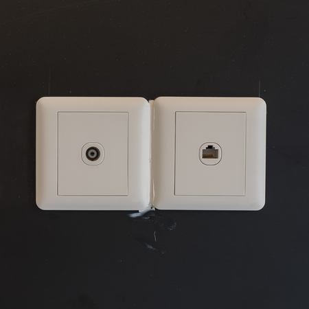 white electric plugs or outlet on wall, with tv and tel, interior design
