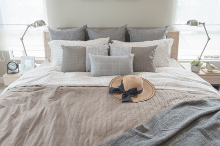 contemporary style bedroom with earth tone color pillows on bed, interior design conceptの写真素材
