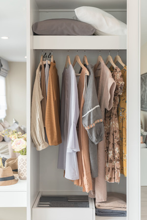 wooden wardrobe with clothes hanging on rail, interior design conceptの写真素材