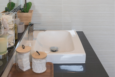 Bathroom interior in new luxury home, sink with faucet and decoration set, white washbasin and...