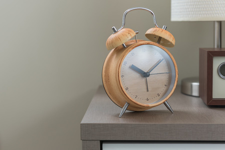 wooden modern alarm clock on bed in modern bedroom designの写真素材