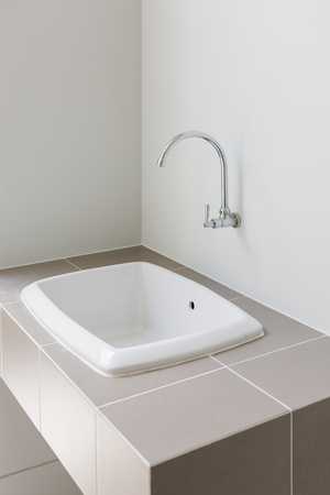 modern sink on counter with faucet in wall, interior design conceptの写真素材
