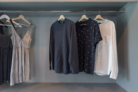 modern closet with clothes hanging on rail, white wooden wardrobe, interior design conceptの写真素材