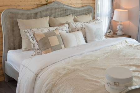 classic bedroom style with set of pillows on bed and classic lamp in white color tone, interior design decoration conceptの写真素材