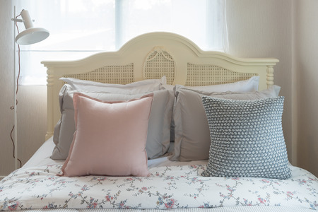 classic bedroom style with set of pillows on bed and classic lamp in white color tone, interior design decoration conceptの写真素材