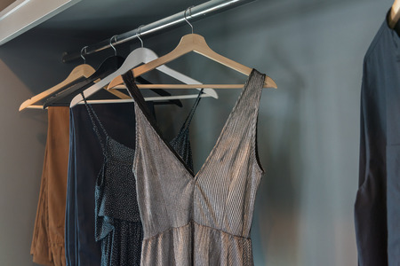 modern closet with clothes hanging on rail, white wooden wardrobe, interior design conceptの写真素材