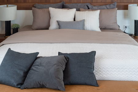 modern bedroom with modern lamp on table side and set of pillows on bed, interior design concept decorationの写真素材