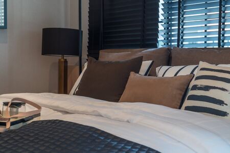 modern bedroom with set of pillows and cushions on bed, interior design concept decorationの写真素材