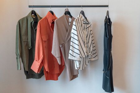modern wardrobe with set of clothes hanging on rail, modern closet interior design conceptの写真素材