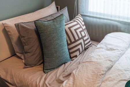 modern bedroom with set of green pillows on bed, interior design concept decorationの写真素材
