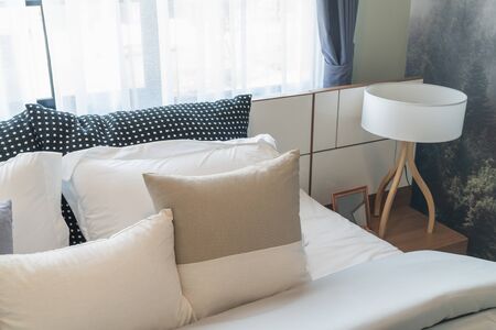 modern bedroom with set of pillows and cushions on bed, interior design concept decorationの写真素材