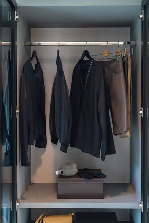 modern wardrobe with set of clothes hanging on rail, modern closet interior design conceptの写真素材