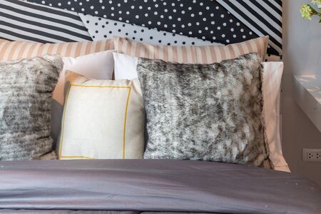 modern bedroom with set of pillows on bed, interior design concept decoration