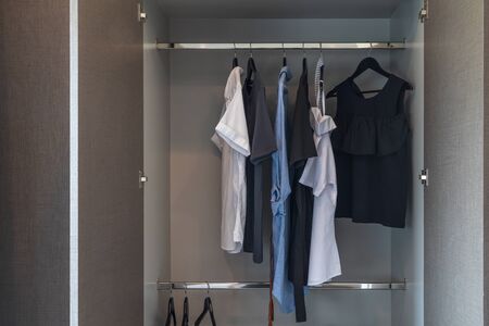 modern wardrobe with set of clothes hanging on rail, modern closet interior design conceptの写真素材