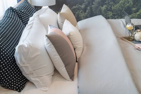 modern bedroom with set of pillows and cushions on bed, interior design concept decorationの写真素材